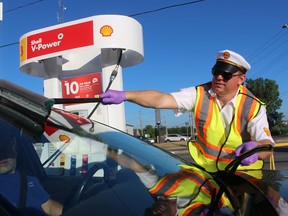 Mike Parkhouse, with Shell Canada, cleans the windshield for one of the drivers who took advantage of the company's offer of free gas Thursday morning at the Don Holden's Shell station in Sarnia.