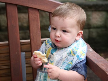 Jackson Mizuik, 10 months, is all smiles while munching on a pyrohy at the Ukrainian Centre's Blueberry Garden Party in Sudbury, Ont. on Thursday July 21, 2022. Food available included pyrohy, cabbage rolls, blueberry pyrohy, crepes with cream cheese filling and blueberry sauce, and a variety of blueberry desserts. John Lappa/Sudbury Star/Postmedia Network