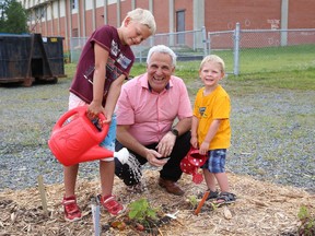 Nickel Belt MP Marc Serre looks on as Louie Dubien, 7, and his brother, Gilles, 3, water a strawberry plant at a pollinator garden at St. Paul the Apostle Catholic Elementary School in Coniston, Ont. on Wednesday July 27, 2022. The garden was created thanks to a Sudbury Shared Harvest project and supported by the federal government's New Horizons for Seniors Program. John Lappa/Sudbury Star/Postmedia Network
