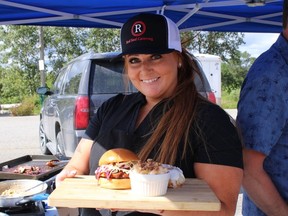 Jessica Gateman, owner and executive chef of Red Seal Catering, serves smoked brisket on a brioche bun with coleslaw, 