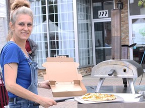 Natalie Sauvageau serves up organic pizza from the maple wood-fueled pizza oven at the Fauxmagerie.  The organic pizza is made with Fauxmagerie cheese made with nuts and seeds.  It is served on their summer patio Wednesday to Friday from noon to 4 pm NICOLE STOFFMAN/The Daily Press