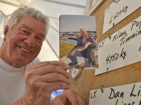 Alan Pope, a former minister of natural resources from Timmins, was, among other things, an avid fisherman. He is seen here holding a photo of a lake trout he caught while participating in a fishing derby in Owen Sound in Aug. 26, 2017. Pope died in Calgary on Friday following heart surgery. He was 76.

File/Postmedia Network