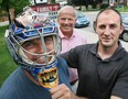 Chris Ames (left), was all smiles Friday August 5, 2011 under the protective covering of Curtis Sanford's (right) goalie mask. It was designed by the Columbus Blue Jackets' goalie and painted by Ottawa area artist Frank Cipra and was worn by Sanford during the last half of the 2010-11 hockey season while Sanford was a goalie for the AHL Hamilton Bulldogs. Sanford donated the mask to be raffled during the 2011 Rec Centre Hockey Challenge Presented by Bruce Power, on Sept 17, 2011 at the Lumley Bayshore. The mask is decorated with images of Owen Sound heroes Harry Lumley and Billy Bishop. Sanford said "It is a small token of my appreciation for what Owen Sound has given to me". James Masters/ Sun Times file photo