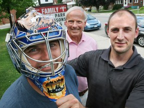 Chris Ames (left), was all smiles Friday August 5, 2011 under the protective covering of Curtis Sanford's (right) goalie mask. It was designed by the Columbus Blue Jackets' goalie and painted by Ottawa area artist Frank Cipra and was worn by Sanford during the last half of the 2010-11 hockey season while Sanford was a goalie for the AHL Hamilton Bulldogs. Sanford donated the mask to be raffled during the 2011 Rec Centre Hockey Challenge Presented by Bruce Power, on Sept 17, 2011 at the Lumley Bayshore. The mask is decorated with images of Owen Sound heroes Harry Lumley and Billy Bishop. Sanford said "It is a small token of my appreciation for what Owen Sound has given to me". James Masters/ Sun Times file photo