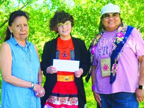 Kennedy Bruno presents board members of the Ermineskin Women's Shelter a cheque for $400, proceeds from her orange shirt sales, and a donation from the Town of Bruderheim.