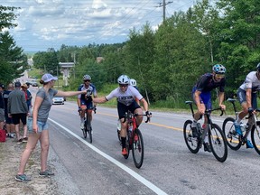 Hayden Kelso takes a bottle of water from his girlfriend Jenna Korn during the Provincial Road Championships in East Ferris on Monday. More than 150 riders competing in 12 categories from Ontario, Quebec and British Columbia participated in the event.