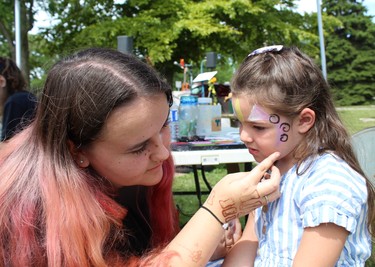 Madi Carter gives five-year-old Paige Schram of Vittoria a new look on Sunday, July 31 at the Simcoe Heritage Friendship Festival. MICHELLE RUBY