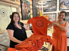 Stacey Shearing, left, and Ellie Lagrandeur, right, pose with the new orange shirt collection available at their gift and art gallery in downtown Fort Saskatchewan, Dreamcatchers Gift and Art Gallery. Photo Supplied.