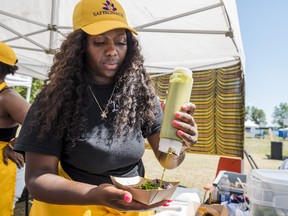 Kennya Verdieu from Lakou Kaii puts the finishing touches on tacos available during the Canadian Artistic Food Expo at Zwick's Park in Belleville on Saturday. ALEX FILIPE