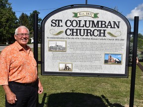 Tom Melady (left) and Nancy Kane stand beside a new sign marking the site of the now torn down St. Columban Catholic Church in the village. The sign was officially dedicated during a brief ceremony Aug. 7. ANDY BADER