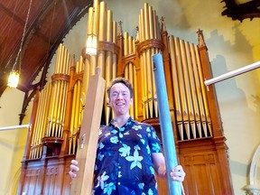 St. Andrew's United Church Pastor Greg Simpson holds two of the 2,600 pipes in the church's pipe organ that are being cleaned in preparation of a celebration planned for next year to mark the 100th year of the Casavant pipe organ being located in the Chatham church. Ellwood Shreve/Postmedia