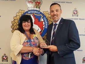 Chatham-Kent Police Service employee Kristine Jarvis, who works in the Canadian Police Information Centre unit, was a finalist for the community role model award from the Police Association of Ontario. She's shown with association president Mark Baxter at police headquarters on Wednesday. (Trevor Terfloth/The Daily News)