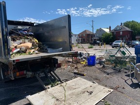 Clean-up efforts are underway to remove an encampment at the former Midas location at the corner of Main Street East and Fisher Street.
