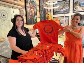 Stacey Shearing, left, and Ellie Lagrandeur, right, pose with the new orange shirt collection available at their gift and art gallery in downtown Fort Saskatchewan, Dreamcatchers Gift and Art Gallery. Photo Supplied.