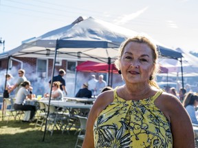 Suzanne Andrews, General Manager of the Quinte West Chamber of Commerce, poses for a portrait as business leaders and entrepreneurs enjoy the chamber's member appreciation BBQ behind her on Wednesday in Trenton, Ontario. ALEX FILIPE