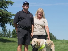 Kevin Frost, 55, and his golf coach Loretta Lachance from Orleans brought his service dog Lewis along for a nine-hole practice round Wednesday at The Greens at Renton, preparing for the Canadian Blind Golf Championships on Thursday and Friday. CHRIS ABBOTT