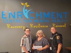 Inspector Sheri Meeks, right, and Health and Wellness Committee Co-Chair Claire Moore, left, present a donation of over $600 to Enrichment Centre for Mental Health Executive Director Sandie Sidsworth, centre. Submitted.