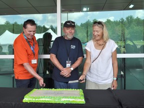 CNL President and CEO Joe McBrearty, AECL President and CEO Fred Dermarkar and Deep River Mayor Suzanne D’Eon cut into a cake at CNL’s Aug. 6 open house.