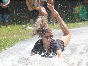 Township of Laurentian Valley volunteer firefighter Olivia Parcher cools off while showing the kids how it's done on the firefighters' slip and slide at Stafford Party in the Park on Aug. 6. Anthony Dixon