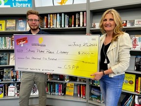Stony Plain Public Library (SPPL) Director Robert McClure (left) accepts a $2,500 check from Michelle Zoschke (right) of the Town's Coordinated Suicide Prevention Program (CSPP) on July 25, 2022. Photo supplied by SPPL.