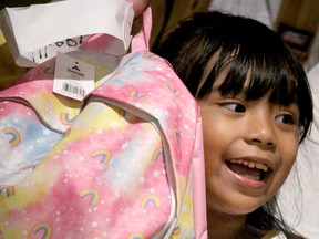 Atheena Yapchiongco, 6, shows off the school bag she received during Centre for Social Justice and Good Works's I Love to Move social at Marconi Cultural Event Centre on Wednesday, Aug. 17, 2022 in Sault Ste. Marie, Ont. (BRIAN KELLY/THE SAULT STAR/POSTMEDIA NETWORK)