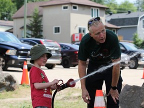 Henry Madge, 4, enjoys using the fire hose from the Callander Fire Department during Saturday's Sirens in the Park. Callander firefighter Dan Depencier keeps a close eye on the possible future recruit.