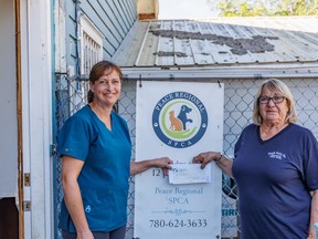 Michelle Waites (left) of the SPCA accepting donation from Joan Setz (right).