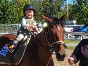 Freya Garner, 22 months, rides Mayhem alongside her mother Fionna during the horse show competition at the Shannonville World’s Fair in Shannonville on Saturday. Garner’s mom used to run the event and now passes her knowledge onto her young daughter. JAN MURPHY