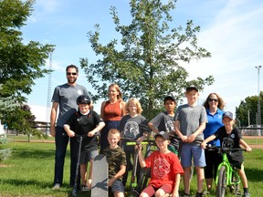 The Optimist Club of Mornington and its local partners are hoping to raise $250,000 toward the construction of an All Wheels Park at the Perth East Recreation Complex in Milverton.  Pictured, local Optimists and some young cyclists, skateboarders and scooter riders pose for a photo where the new All Wheels Park will be located, at the edge of the recreation-complex parking lot near the baseball diamonds.  Galen Simmons/The Beacon Herald/Postmedia Network