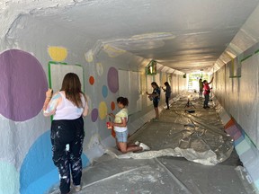 Youth volunteers from the City of Spruce Grove's Leaders in Training Program help paint Justin Beamish's new public mural titled "United" in the Grove Drive tunnel. The mural was officially unveiled on Wednesday, Aug. 31. Photo supplied.