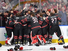 Goalie Brett Brochu (30) of Tilbury, Ont., celebrates with Team Canada teammates after winning the gold-medal game against Finland in the IIHF world junior championship on August 20, 2022, at Rogers Place in Edmonton, Alta. (Photo by Andy Devlin/Getty Images)