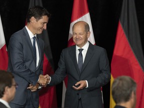 Prime Minister Justin Trudeau and German Chancellor Olaf Scholz shake hands at the start of a signing ceremony after signing a deal to kick-start a transatlantic hydrogen supply chain, on Tuesday, August 23, 2022 in Stephenville, Newfoundland and Labrador. The head of an advocacy group pushing to decarbonize Canada's public transit systems says experience with public transit in Canada is any indication, getting the projects off the ground may be more difficult than expected. THE CANADIAN PRESS/Adrian Wyld