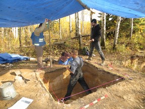 L-R: Reid Graham of the Manitoba Historic Resources Management Branch, Todd Kristensen of the Archaeological Survey of Alberta and Robin Woywitka of MacEwan University excavate an archeological dig north of Fort McMurray in a handout photo. Photo by Brittany Romano