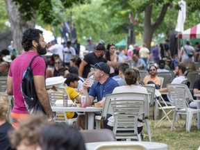 People enjoy food and drink at the London Ribfest and Craft Beer Festival in Victoria Park in London on Monday, Aug. 1, 2022. The event, the first after pandemic health restrictions were lifted, drew a record crowd, an organizer says. (Derek Ruttan/The London Free Press)