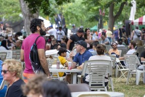 People enjoy food and drink at the London Ribfest and Craft Beer Festival in Victoria Park in London on Monday, Aug. 1, 2022. The event, the first after pandemic health restrictions were lifted, drew a record crowd, an organizer says. (Derek Ruttan/The London Free Press)