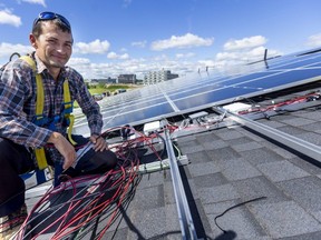 Ukrainian refugee Misha Hermanenko installs wiring for solar panels at Sifton's West 5 townhouse complex in London. Hermanenko, who worked in solar power in the Ukraine, was hired by German Solar. Photograph taken on Tuesday, Aug. 9, 2022. (MIKE HENSEN/The London Free Press)