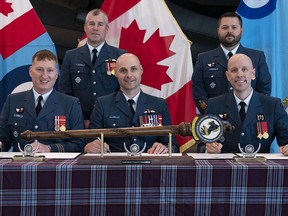 Incoming 8 Air Maintenance Squadron (8AMS) Commander, Lieutenant Colonel Caden Stiles, 8 Wing Commanding Officer Colonel Leif Dahl, and outgoing 8AMS Commander Lieutenant Colonel Adam Emond sign over command at the 8AMS Change of Command ceremony at 8 Wing Trenton on Thursday. CPL LUKE BARRIE/8 WING IMAGING

Photo by:
