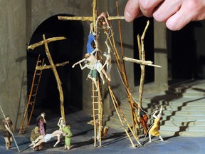 A man adjusts a miniature crucifix scene at the Oberammergau Passion museum in the southern German town of Oberammergau in 2010. The Oberammergau Passion play, first staged in 1634 to ward off a plague epidemic, is making a comeback this year. The play, staged every 10 years, was delayed in 2020 due to the pandemic.     A OLIVER LANG/AFP/Getty Images