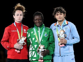 Silver medalist Madison Parks of Team Canada, Gold medalist Miesinnei Mercy Genesis of Team Nigeria and Bronze medalist Pooja Gehlot of Team India celebrate on the podium following the Women's Wrestling Freestyle 50 kg medal ceremony on day nine of the Birmingham 2022 Commonwealth Games at Coventry Arena on August6.