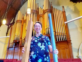 St. Andrew's United Church Pastor Greg Simpson holds two of the 2,600 pipes in the church's pipe organ that are being cleaned in preparation of a celebration planned for next year to mark the 100th year of the Casavant pipe organ being located in the Chatham church.