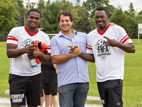 Brett Schuyler, owner of Schuyler Farms is joined by two of his workers Randell Richards (left) and Cemore Gordon at the annual Farms of Norfolk Football Association tournament on Sunday in Simcoe.