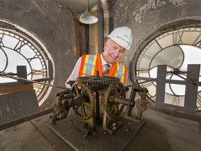 Mayor Kevin Davis looks at the mechanism that drives the hands on the clock in the tower of Brantford City Hall in 2019. Restoration work is slated to begin August 17 on the clock tower because pieces of the acrylic and glass clock dials, and the hands, are in peril of falling. Brian Thompson/Brantford Expositor/Postmedia Network