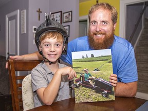 Five-year-old Mason Finucane of Brantford and his father Drew hold a photo of the youngster taking his soap box derby car for a test run.