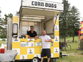 From left: Brandon Shaw and event founder Dave Conway in front of the Cornelia Corn Dog stand on the first day of Cornwall's 2022 Poutine Feast on Thursday August 4, 2022 in Cornwall, Ont. Laura Dalton/Cornwall Standard-Freeholder/Postmedia Network