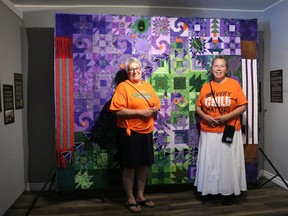 From left: Céline Baillargeon, executive director of ACFO and Iakonikonriiosta, manager of the Native North American Travelling College, standing with the jointly made quilt presented at Akwesasne Friendship Day on Sunday August 7, 2022 in Akwesasne, Ont. Laura Dalton/Cornwall Standard-Freeholder/Postmedia Network