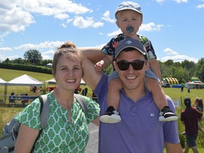 Danica and John Chisholm with son Thomas at the St. Andrews West Community Fest. The children's play area is seen bustling in the background on Saturday August 13, 2022 in St. Andrews West, Ont. Shawna O'Neill/Cornwall Standard-Freeholder/Postmedia Network