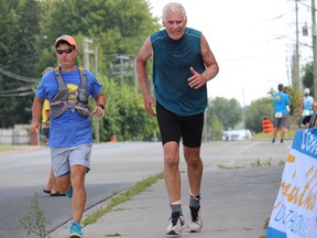 Volunteer Ian Callan (left) runs a portion of the final few metres of an event with Cornwall Triathlon participant David Leigh. Photo on Sunday, August 21, 2022, in Cornwall, Ont. Todd Hambleton/Cornwall Standard-Freeholder/Postmedia Network