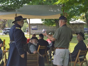 Vince Chiarelli (left), an officer in charge of the Montreal Grays and Blues infantry, speaking to a member of the public about the re-enactment on Saturday August 27, 2022 in South Stormont, Ont. Shawna O'Neill/Cornwall Standard-Freeholder/Postmedia Network