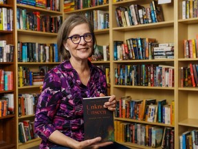 Linda Anne Smith poses with her novel, Unknown, Unseen - Under the Radar at the Found book store in Cochrane on Thursday, Aug. 11, 2022. Smith will be at Found books on Sept. 3, from 11 a.m. to 2 p.m. to sign copies of her new novel.