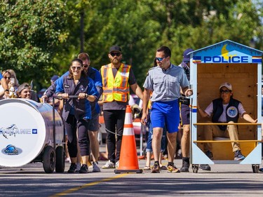 Members of the Cochrane GM and the RCMP teams prepare for some outhouse race action on 1st street in Cochrane on Sunday, Aug. 28, 2022.